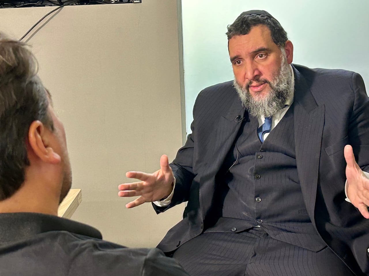 A man sitting, talking to another man