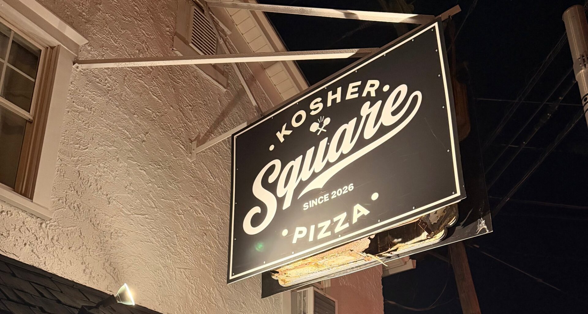 Kosher Square Pizza's hanging storefront sign in Oakhurst, NJ