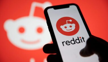 Reddit logo displayed on smartphone with Reddit logo in the background