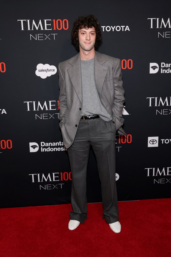 Dominic Sessa attends the Time100 Next Gala in a grey suit, grey sweater, and white shoes.