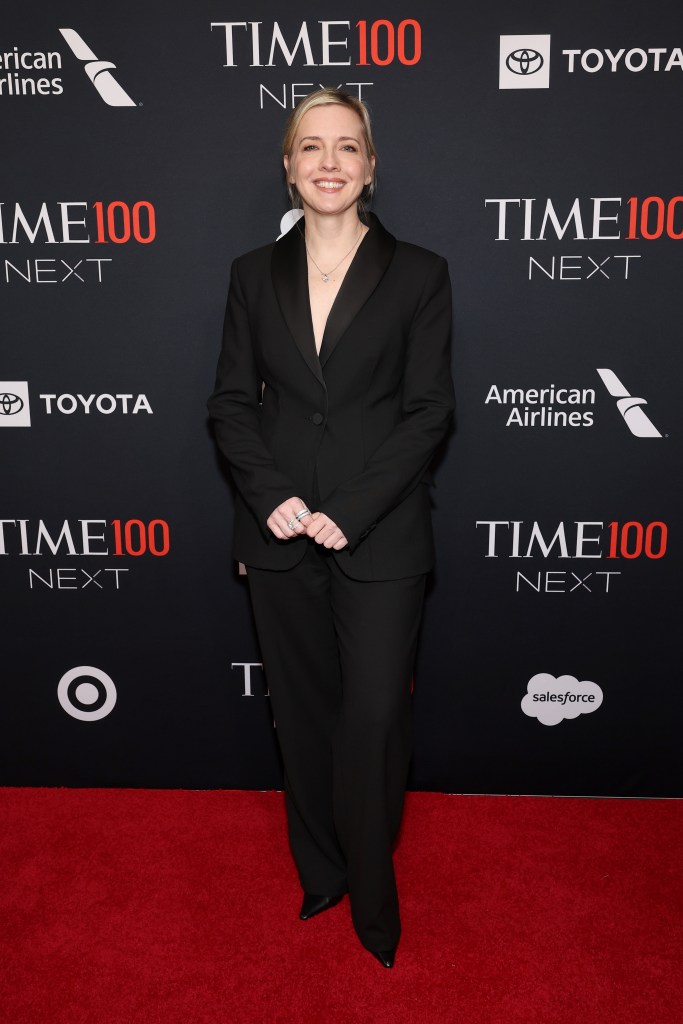Katie Dippold poses on the red carpet at the Time100 Next Gala, wearing a black pantsuit.