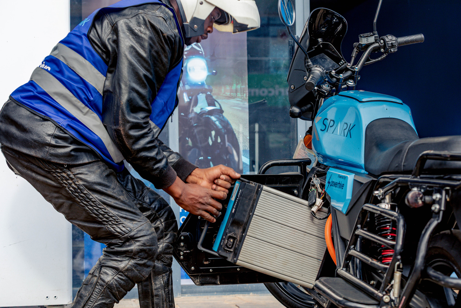 A man pulls a battery out of his motorcyle