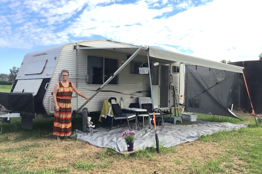 Katharine Morris stands in front of a quite caravan with an awning.