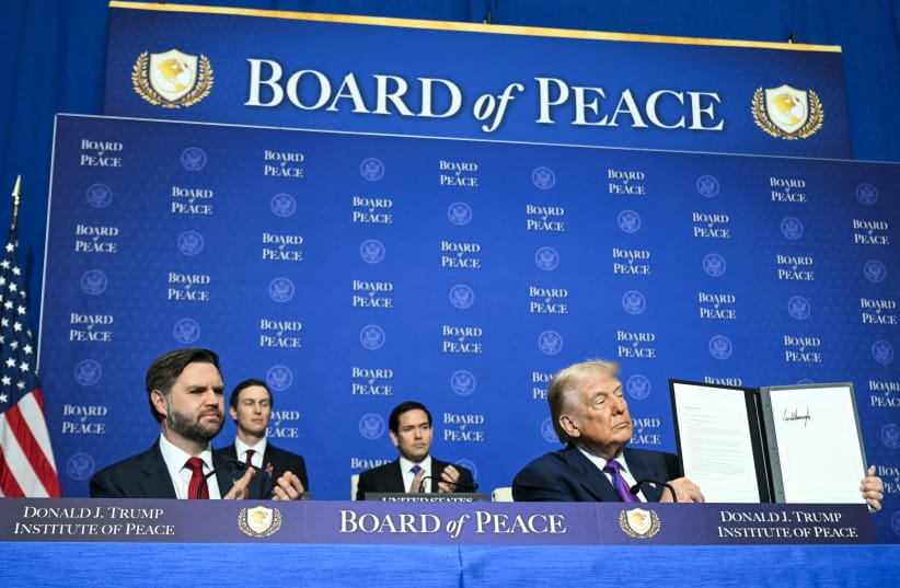 US Vice President JD Vance, Jared Kushner, and US Secretary of State Marco Rubio look on as US President Donald Trump holds up a resolution document that he signed during the inaugural meeting of the Board of Peace at the US Institute of Peace in Washington, DC, on February 19.