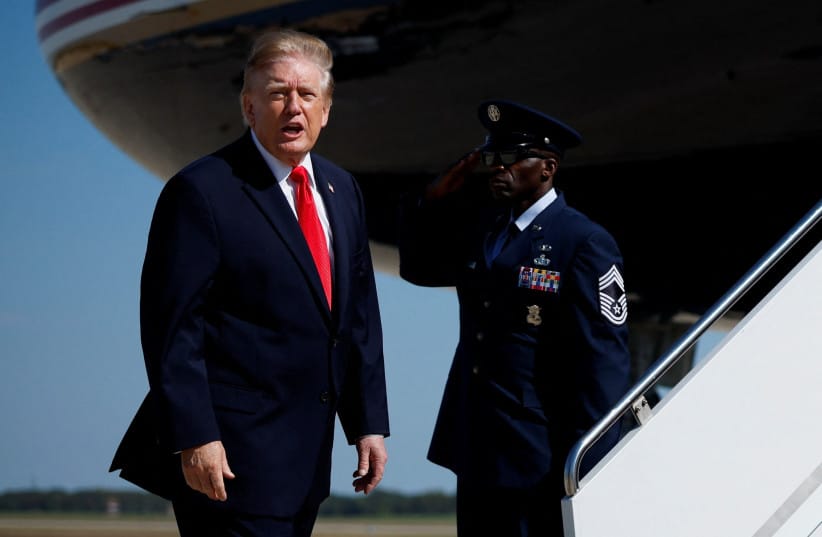 US President Donald Trump stands before boarding Air Force One for a trip to Alaska at Joint Base Andrews, Maryland, US, October 13, 2026