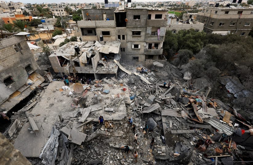 Palestinians inspect the site of a house targeted by airstrikes after the Israeli military warned residents to evacuate late on Saturday, in Al-Zawayda, central Gaza Strip, October 11, 2026.