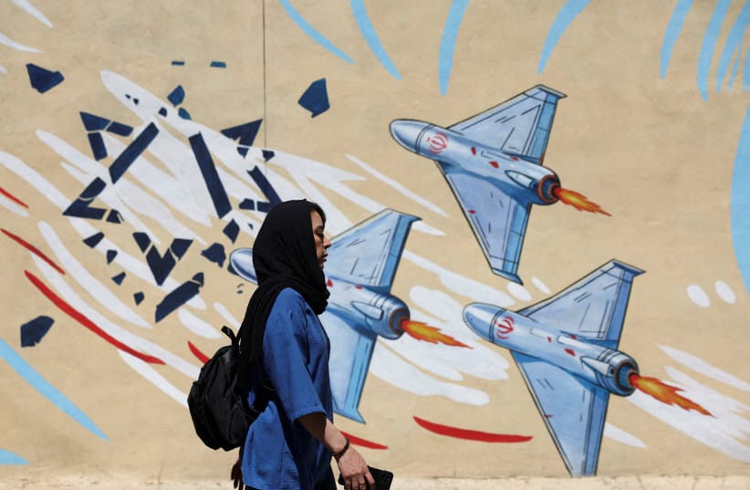 An Iranian woman walks next to an anti-Israeli mural on a street in Tehran, Iran, May 26, 2026 (credit: MAJID ASGARIPOUR/WANA