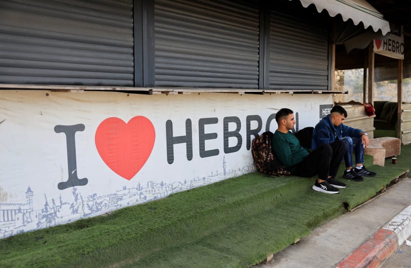 Palestinians sit near the closed entrance of Hebron, in the West Bank, October 24, 2026.