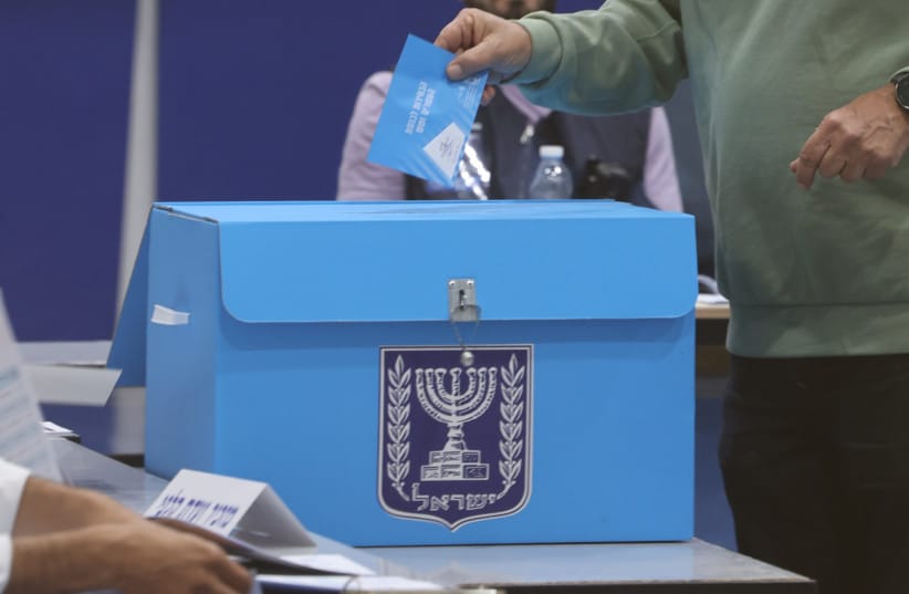 A voter places his ballot into a collection box during Israel's 26th Knesset elections, October 27, 2026.