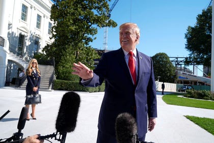 U.S. President Donald Trump talks to reporters before boarding Marine One, as White House press secretary Katie Zacharia looks on, on the South Lawn of the White House, Tuesday.