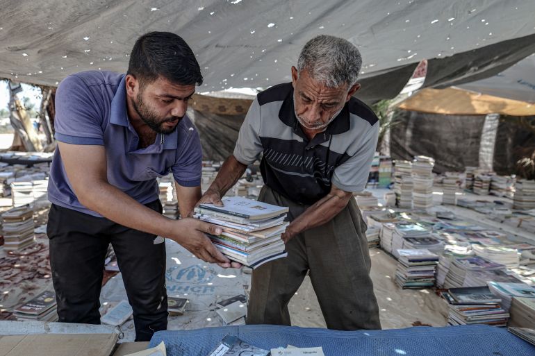 Mohammed Saad and his son sort and organise books in Deir al-Balah, Gaza