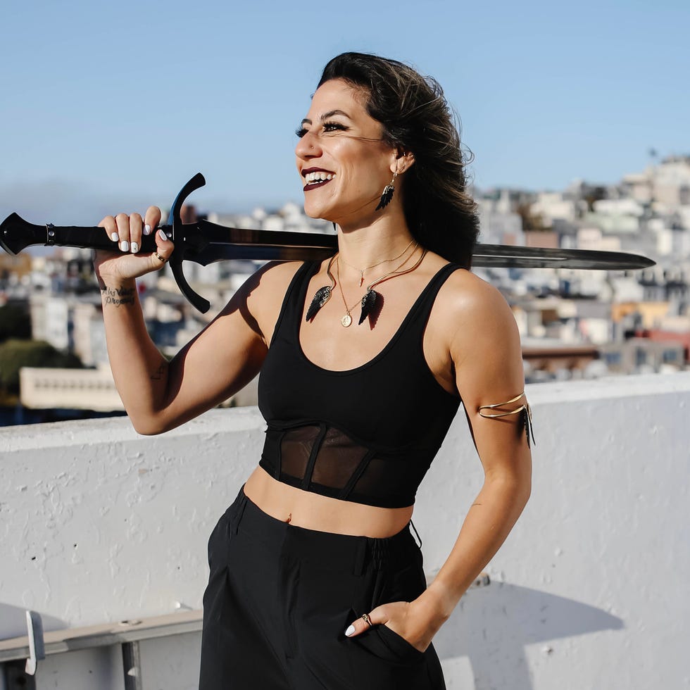 Micro Squad founder Samantha Willens posing with a play sword during a romantasy-inspired workout