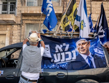 A man ties a Netanyahu election sign at Jerusalem's Mahne Yehuda Market. Credit: Itay Cohen A man ties a Netanyahu election sign at Jerusalem's Mahne Yehuda Market.