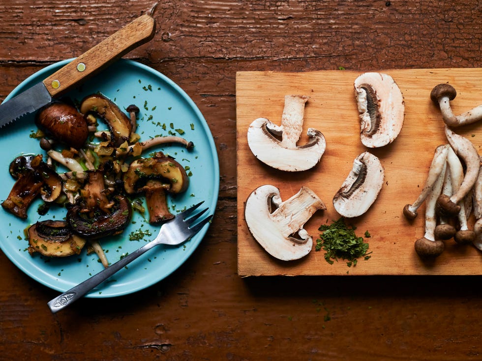 Still life of cooked and raw mushrooms on old brown table still life of cooked and raw mushrooms on old brown table
