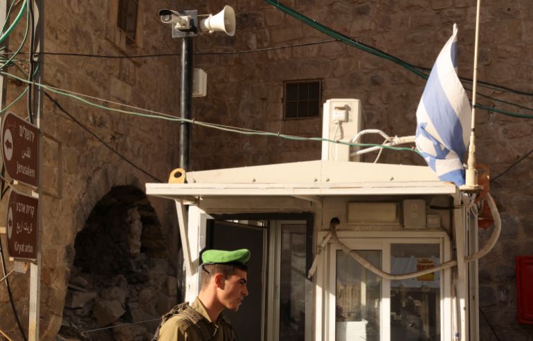 An Israeli soldier stands under a surveillance camera at a checkpoint in the flashpoint Palestinian city of Hebron. Israel’s army has deployed a sweeping personal data collection programme using facial recognition technology against Palestinians in parts of the occupied West Bank
