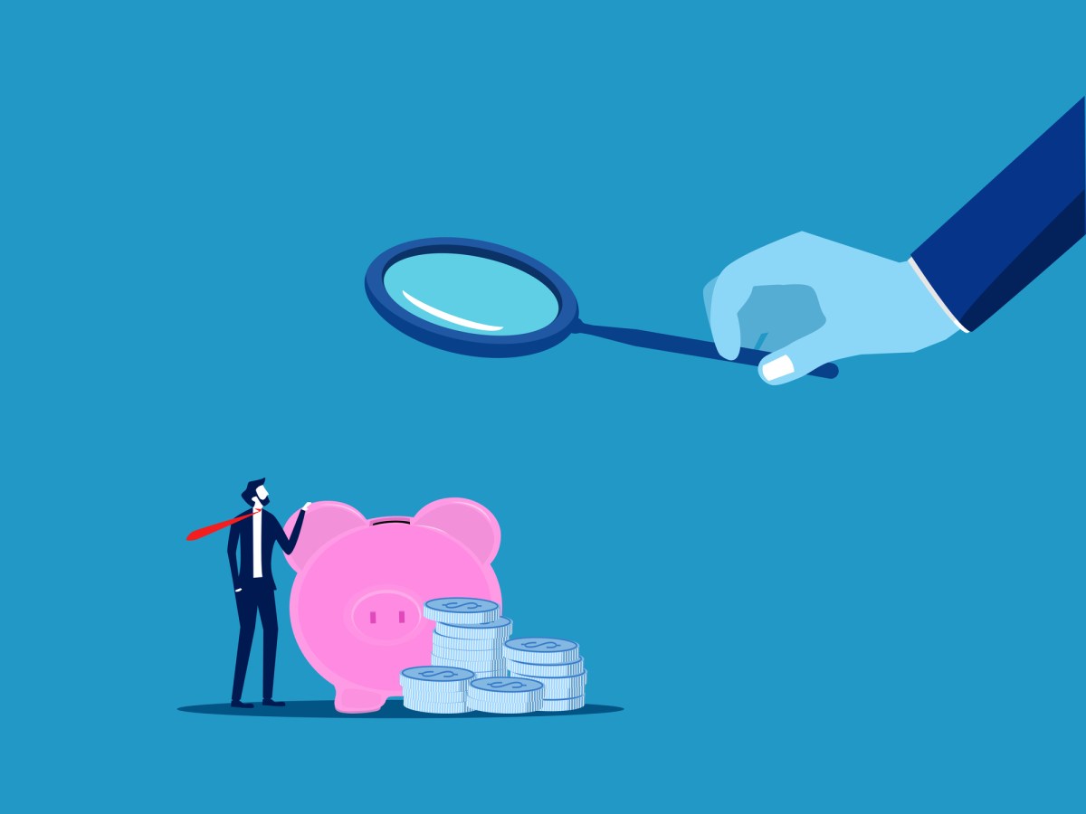 render of hand holding magnifying glass to examine piggy bank.