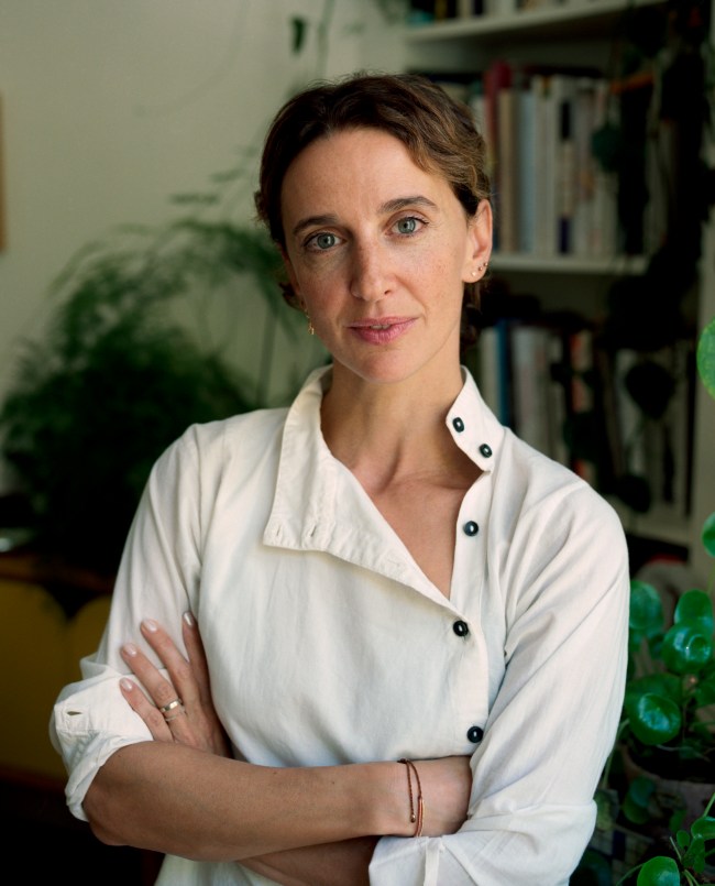 Portrait of Sandra Terdjman in a white button-down shirt, arms folded, against a softly blurred background.