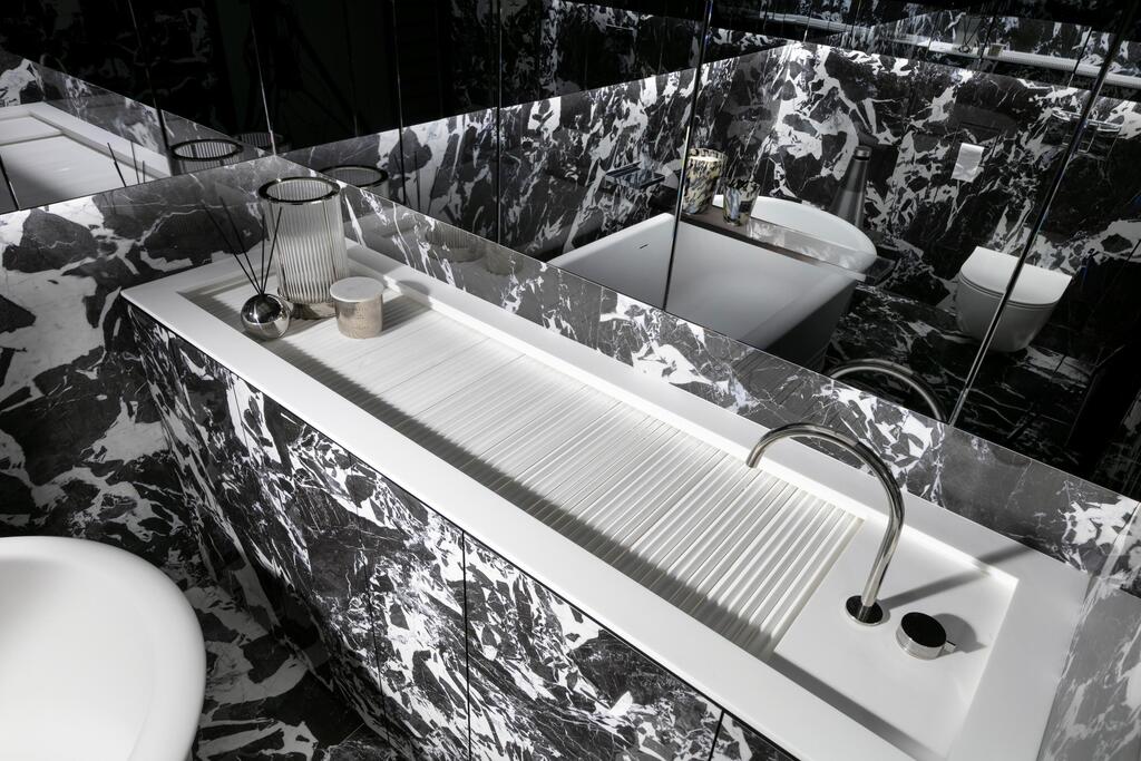A custom-designed sink with water disappearing into narrow grooves (Photo: Elad Gonen) דירה אולטרה מודרנית במגדל תל אביבי, עיצוב: אורון מילשטיין