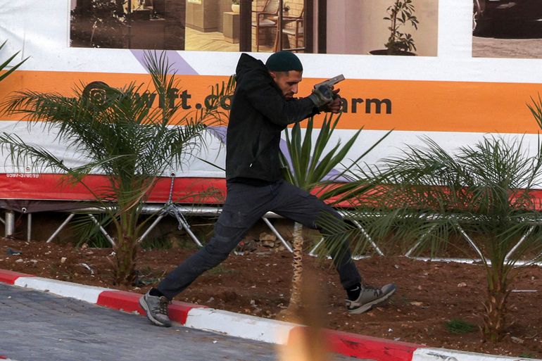 One of two Palestinian gunmen runs during an exchange of fire with Israeli forces at the northern checkpoint of Hebron in the Israeli-occupied West Bank on October 23, 2026 [AFP]