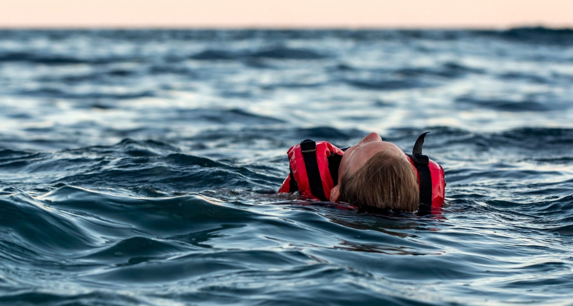 girl in cold water with red lifevest