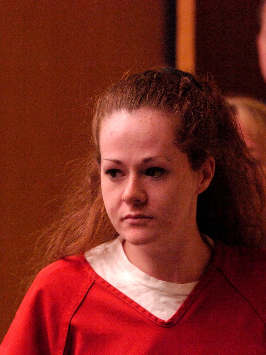 a young woman in a prison uniform enters a courtroom