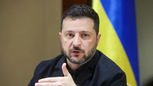 Ukrainian President Volodymyr Zelensky speak to tori pipo. Im dey demonstrate as e siddon for front of di Ukraine flag.