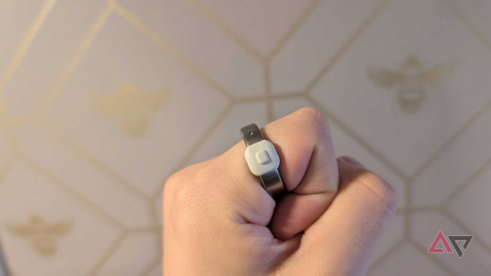 clenched hand wearing silver and white ring