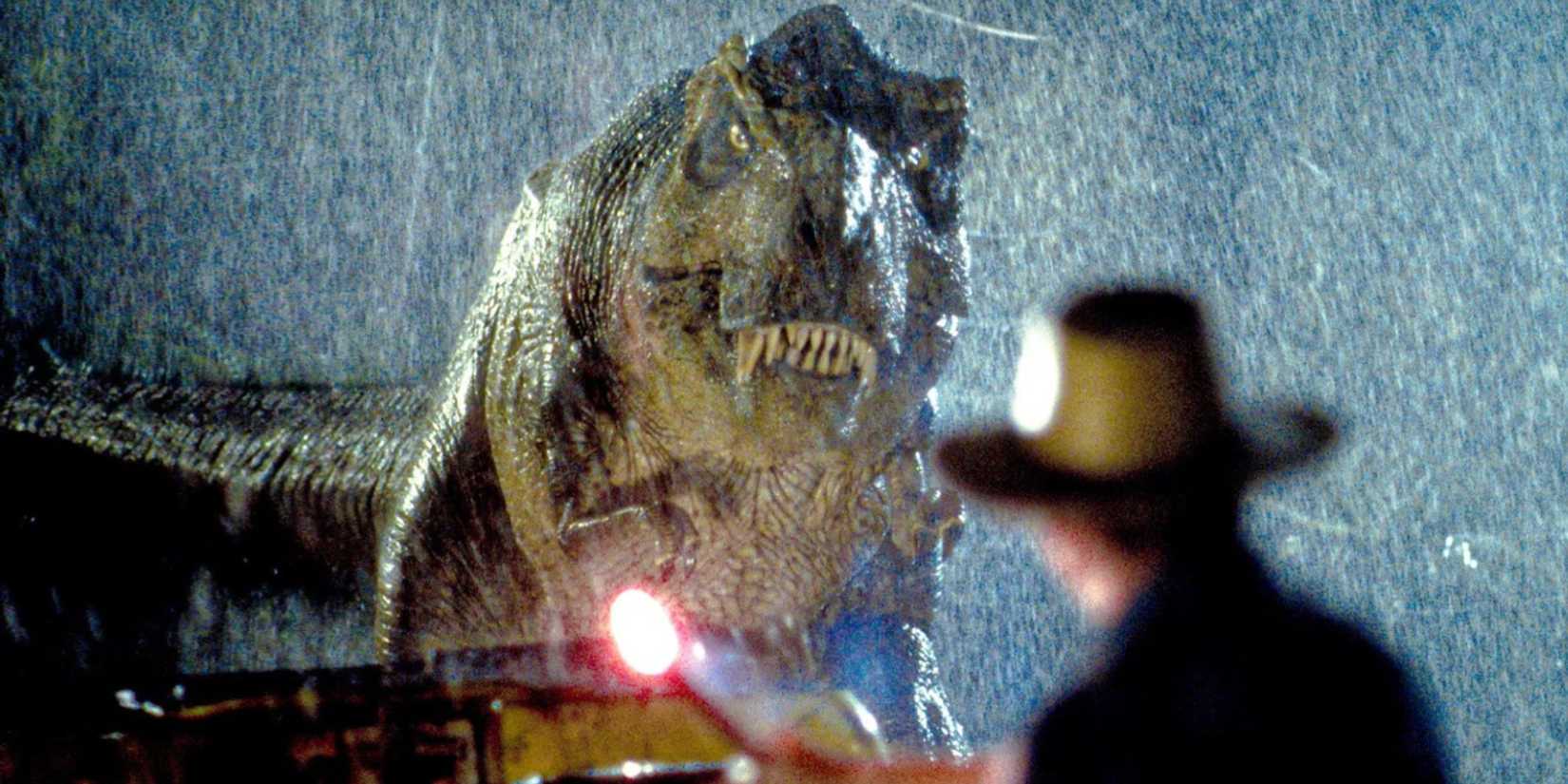 A T. rex looking at a flare in the rain during a tense scene in the original Jurassic Park (1993)