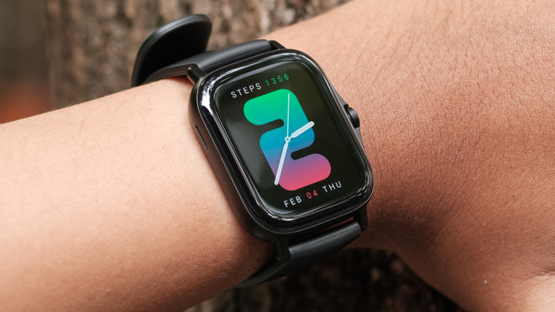 A closeup of a black Amazfit smartwatch displaying the time, date, and a user's steps count