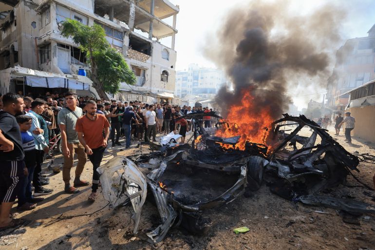 Palestinians gather around a burning a vehicle after it was hit by an Israeli strike, according to health officials, in Gaza City, October 22, 2026. REUTERS/Dawoud Abu Alkas