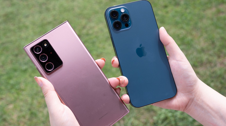 Samsung Galaxy Note 20 held up next to an iPhone 13.