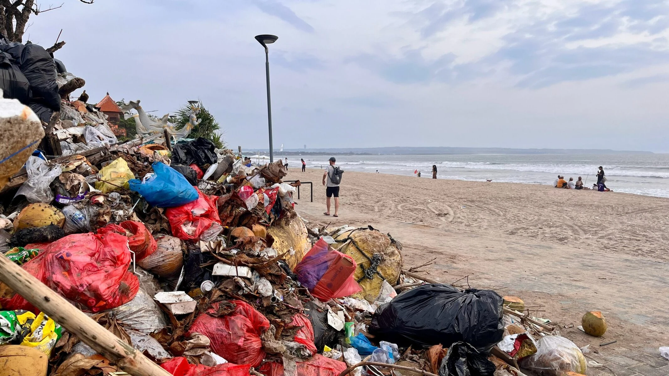 A beach in Bali, Indonesia, with a large pile of garbage on one side