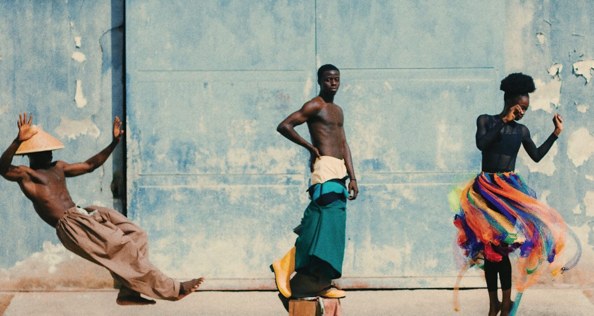 a photo of people dancing against a robins egg blue wall