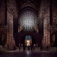 Spherical installation made up of suspended piece of coal illuminated inside a cathedral
