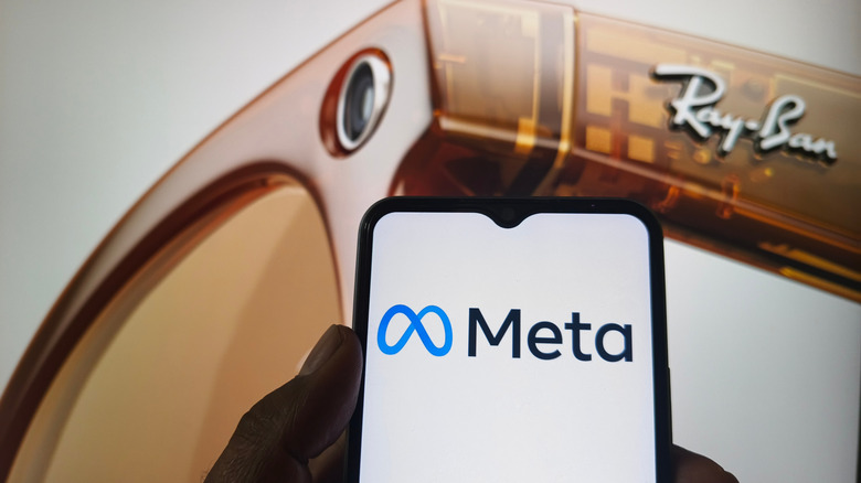 Meta logo displayed on a phone with Ray-Ban Smart Glasses projected in the background.