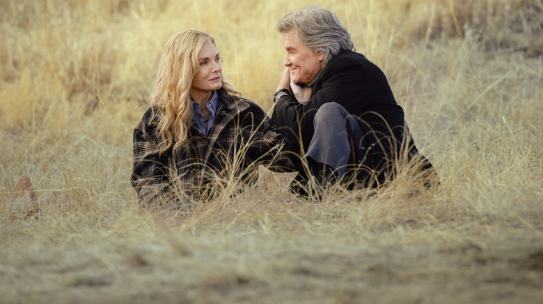 Stacey (Michelle Pfeiffer) and Preston (Kurt Russell) sitting in the grass on 