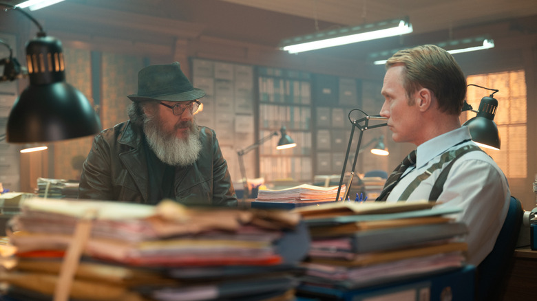 James Spader as Ultron and Paul Bettany as Vision sitting at a clutter desk in VisionQuest
