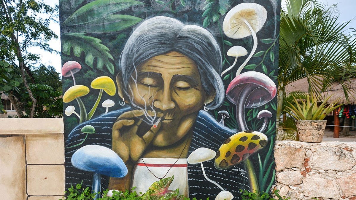 Woman smoking cigarettes at the entrance to Cenote Canunchen in Homun, Mexico.