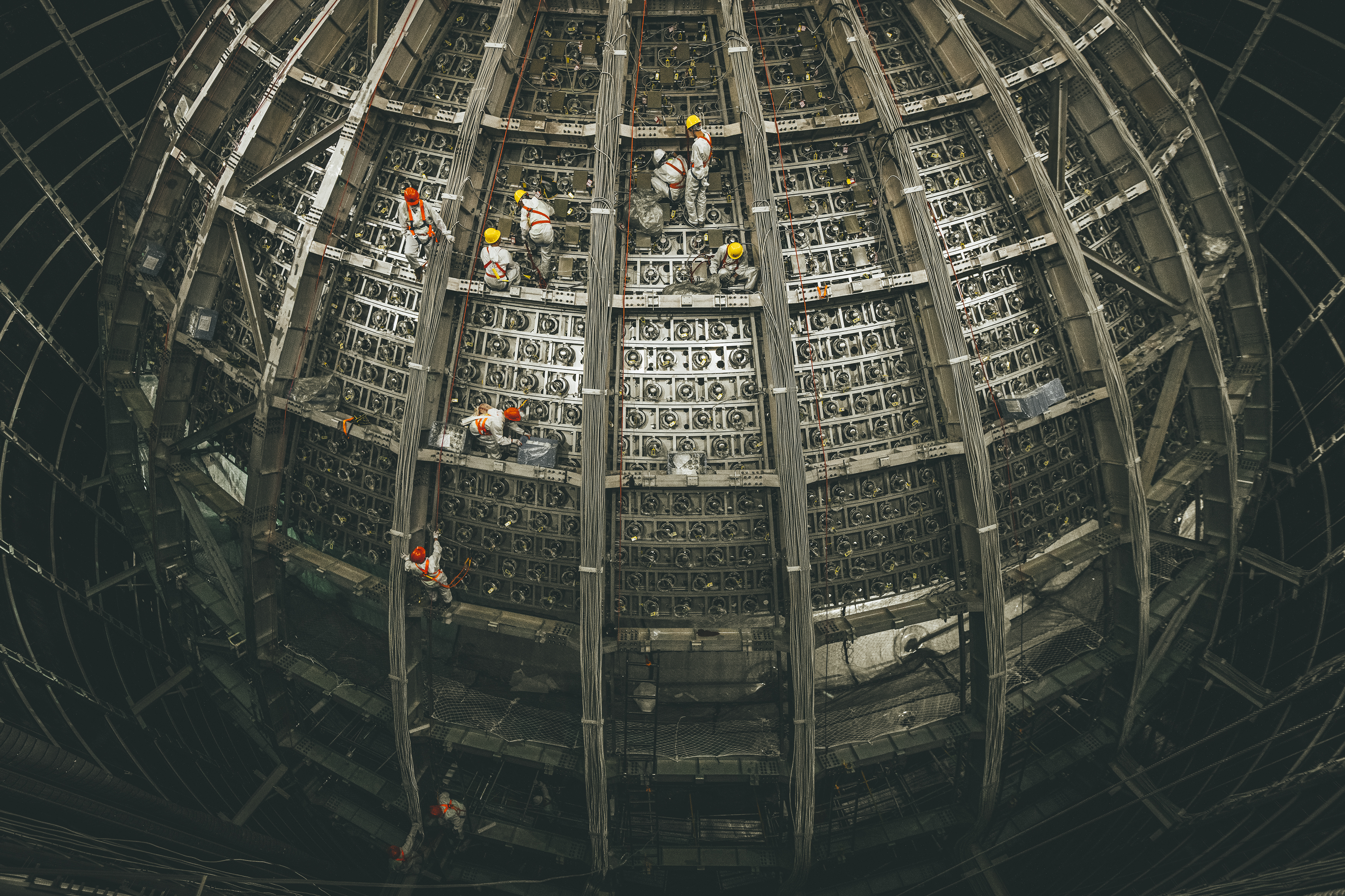 Workers installing detectors at the Jiangmen Underground Neutrino Observatory (JUNO).