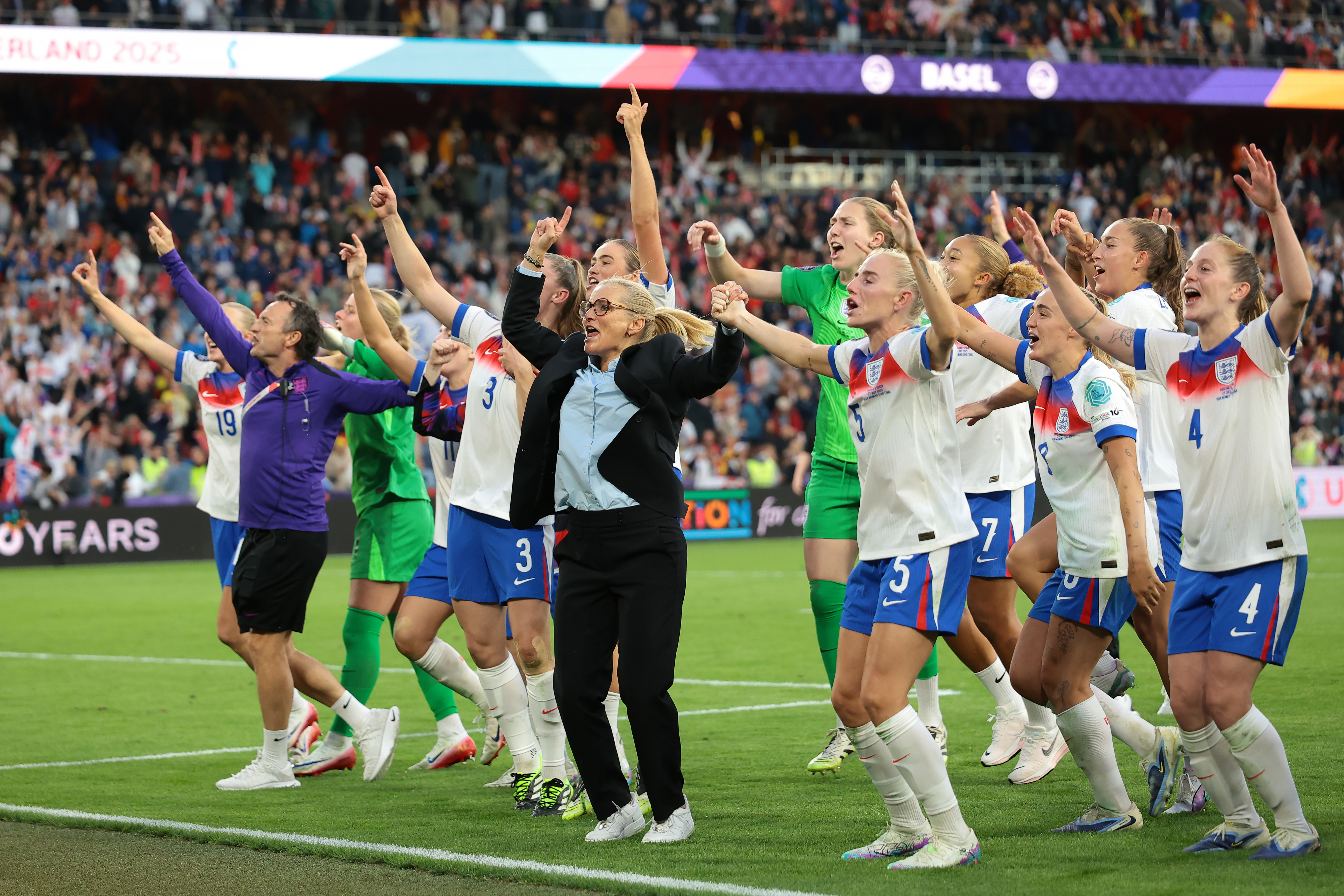 England's women's soccer team and their coach celebrating a victory.
