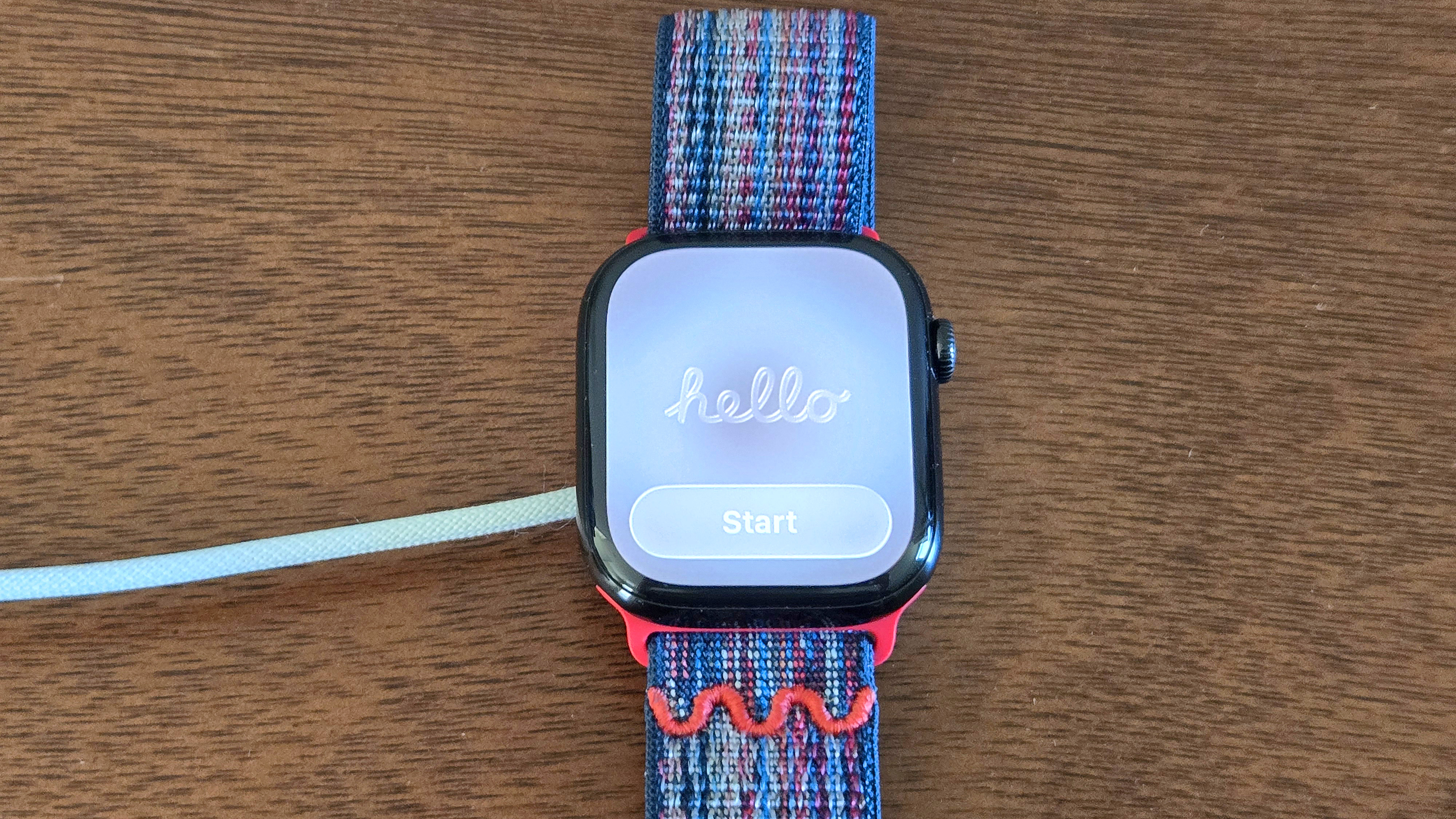 Close-up of the installation process for watchOS 26 showing an Apple Watch Series 10 and iPhone 12 Mini