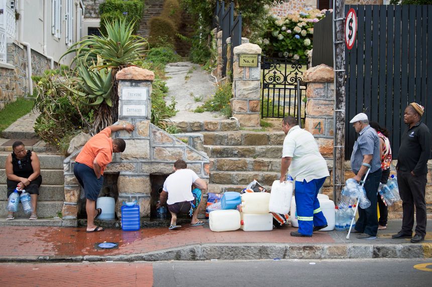 People collect drinking water from pipes fed by an underground spring, in Cape Town on January 19, 2018, as the city battled its worst drought in a century.