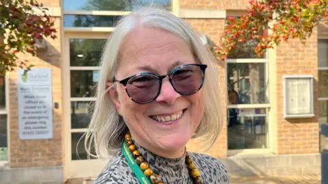 A portrait picture showing Christine Wise smiling at the camera.