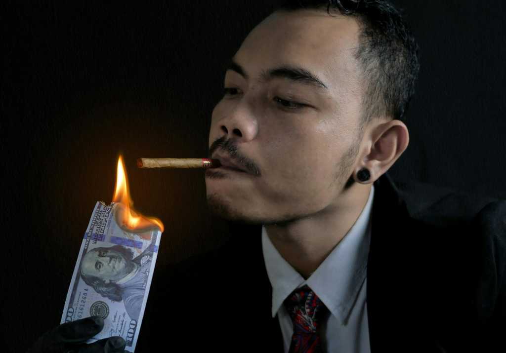 Man Lighting His Cigarette with Burning Bank Note