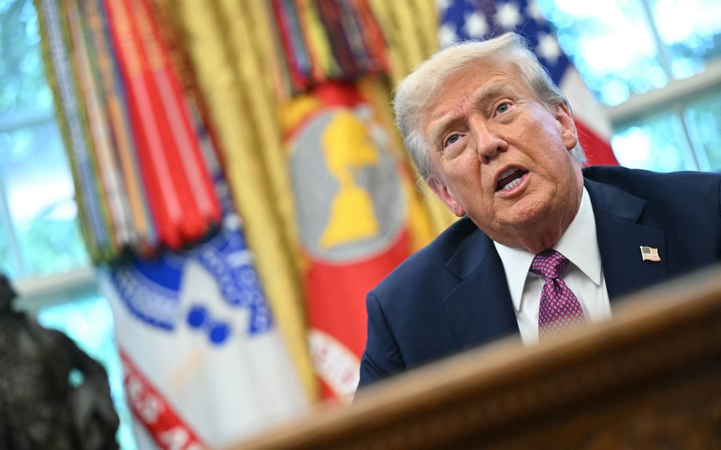 President Donald Trump speaks to reporters in the Oval Office of the White House on Friday.