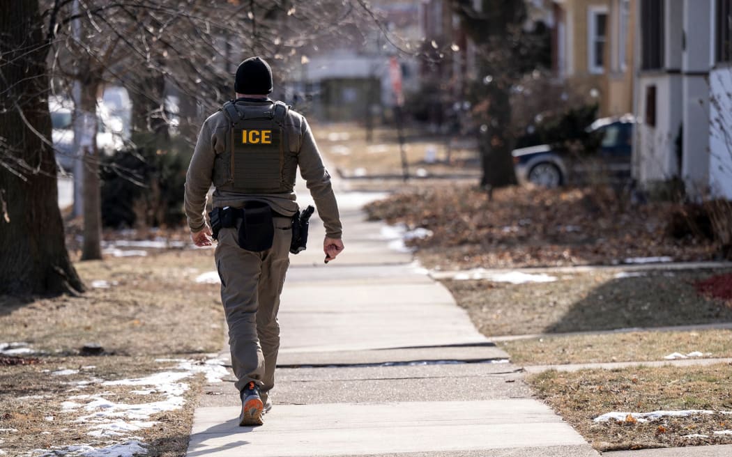 A US Immigration and Customs Enforcement (ICE) agent walks down a street during a multi-agency targeted enforcement operation in Chicago, Illinois, US, on January, 26.
