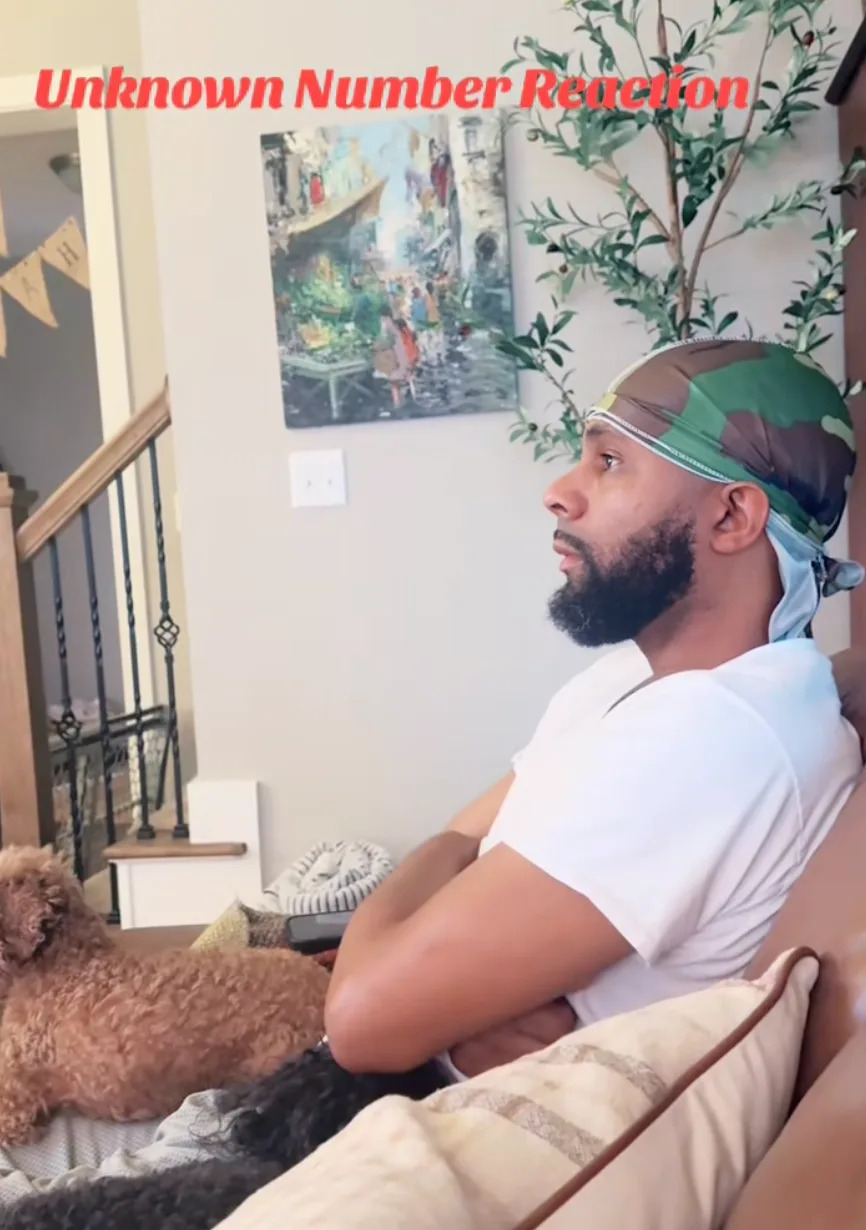 Man with beard and headscarf sits on a couch, arms crossed, looking pensive. Small dog rests beside him. Text above reads "Unknown Number Reaction."