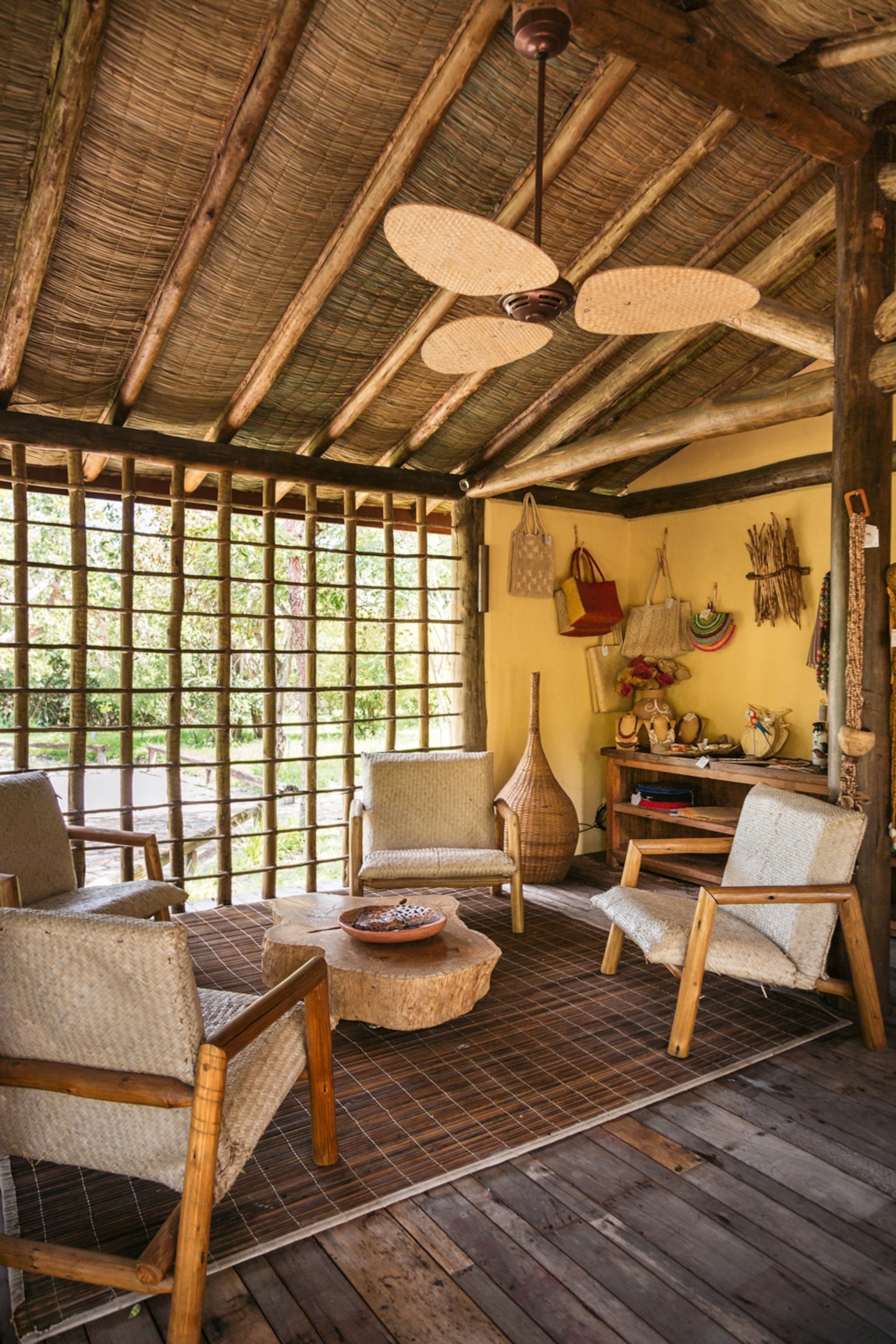 The interiors of a hotel bedroom with rattan furniture and features, checkerboard windows made from tall sticks.