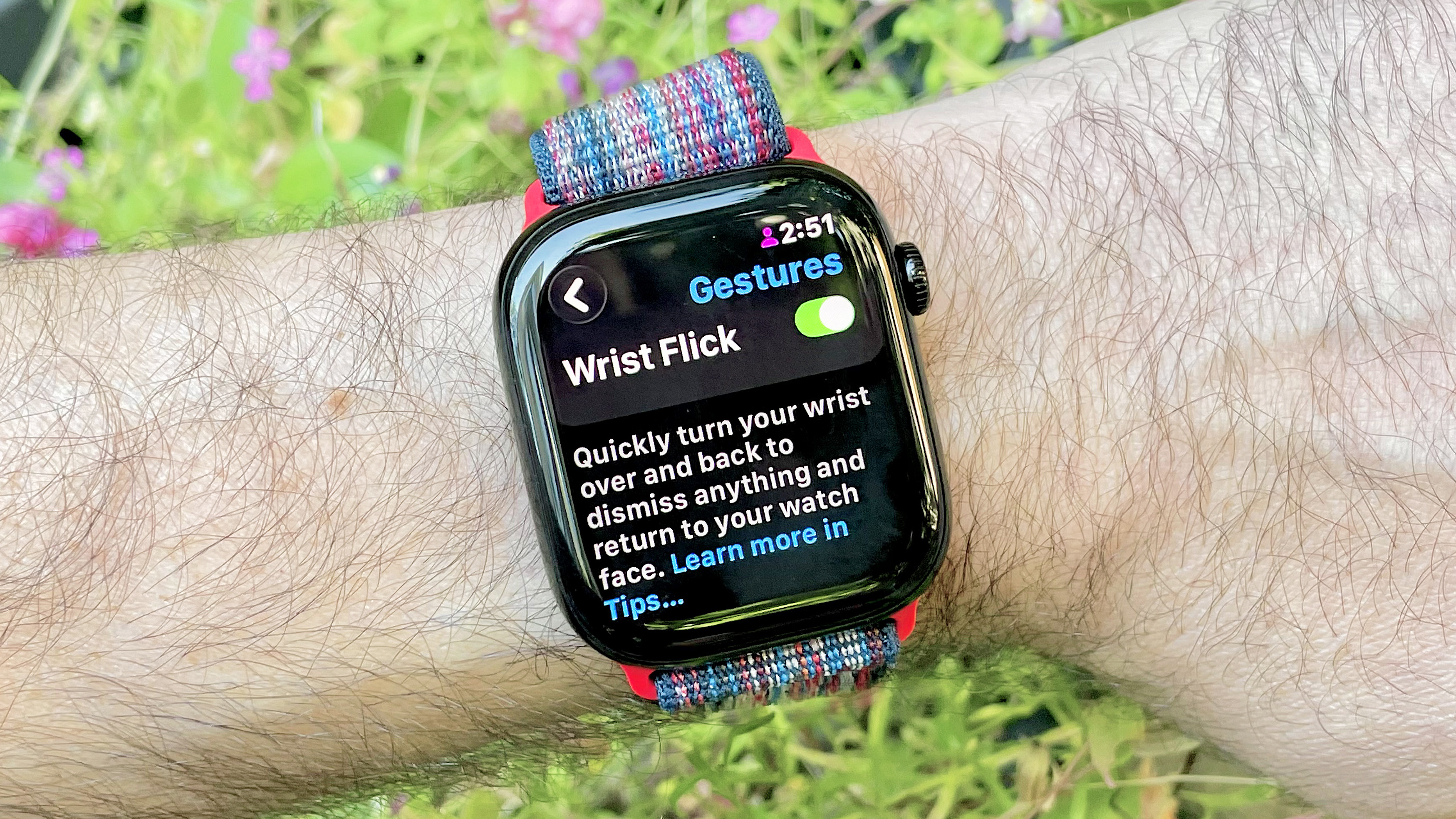Close-up of an Apple Watch 10 on a user's wrist showing the menu option to turn on the new Wrist Flick gesture in watchOS 26