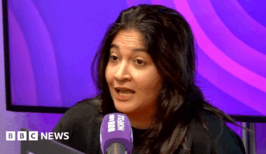 A resident walks with a shovel along a mud-covered road in Hualien on September 24, 2025, following the bursting of a barrier lake during the passing of Super Typhoon Ragasa.